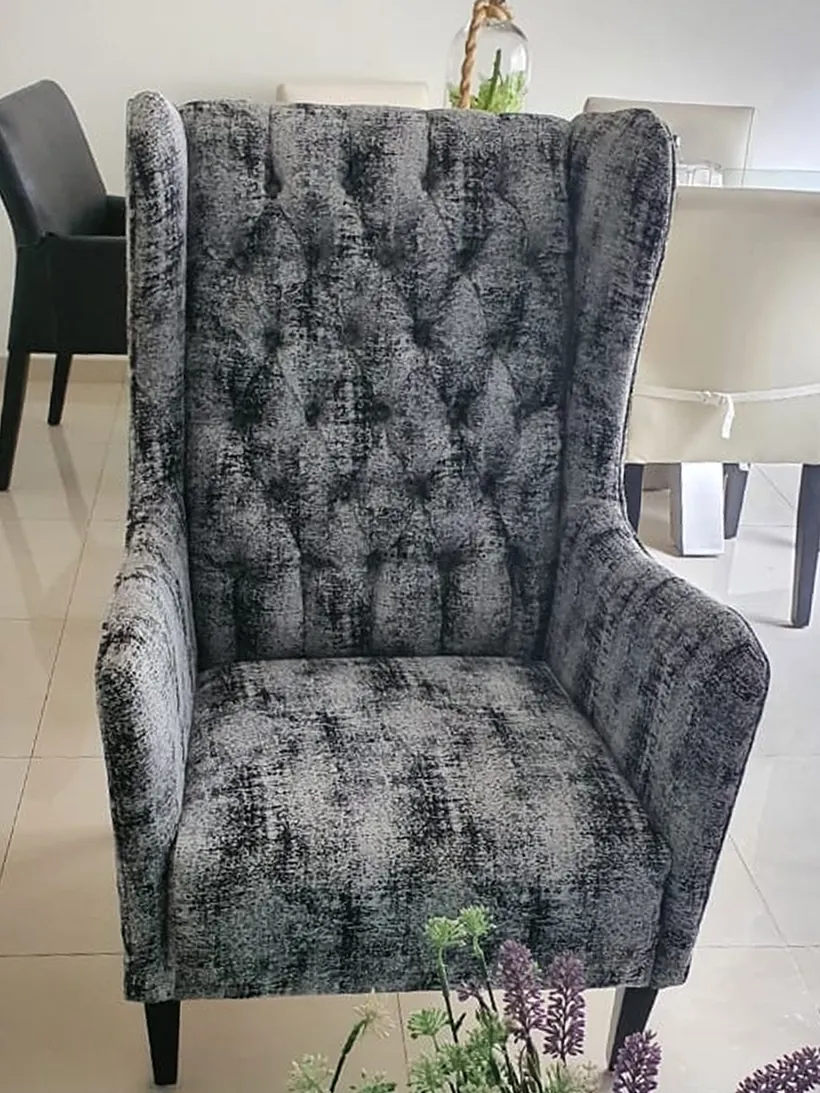 Sillón capitonado tapizado en tela gris