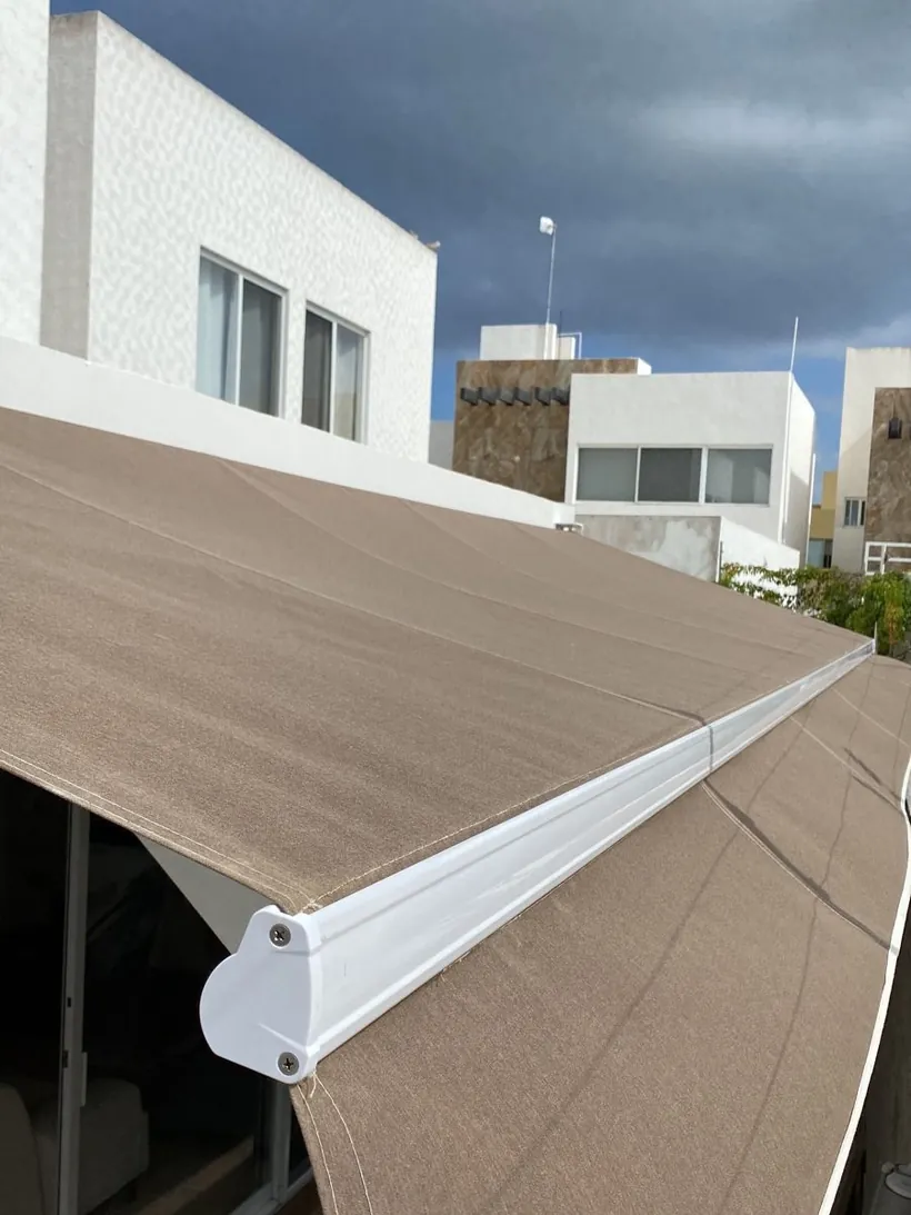 Toldo europeo retráctil en tela café sobre una terraza