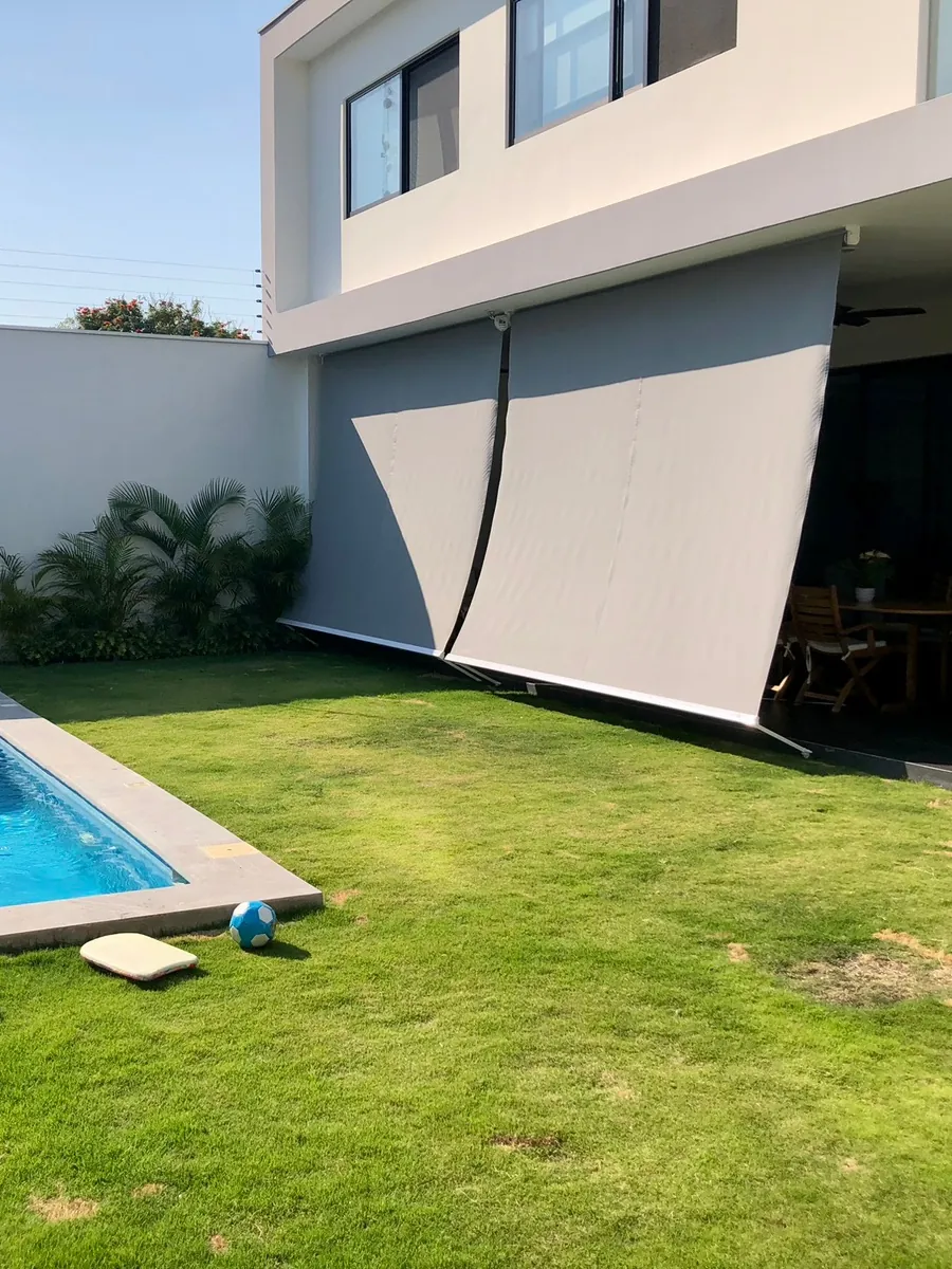 Toldo europeo instalado en la terraza de una casa con alberca